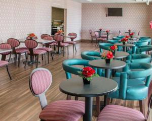 圣马科斯圣马科斯康福特茵酒店的一间带桌椅和鲜花的用餐室