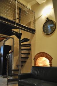 皮斯托亚Appartamento i Fabbri的带沙发和螺旋楼梯的客厅