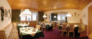 莱赫阿尔贝格伯格兰膳食公寓的用餐室配有桌椅和灯光