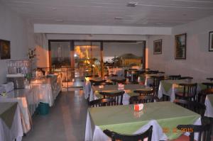 德尔迪阿布罗角Bahía Pindó的餐厅配有桌椅和绿色桌布