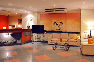 亚松森曼杜阿拉公寓式酒店的客厅配有两张沙发和一台电视机