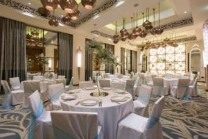 桑给巴尔柏悦桑给巴尔酒店的宴会厅配有白色的桌椅和吊灯。