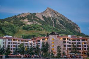 Mount Crested Butte格兰德洛奇套房酒店的一座大建筑,背景是一座山