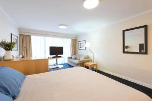 悉尼海滨大道一室公寓的酒店客房,配有床和电视