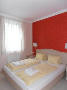 图拉彻霍赫圣丹斯山度假村的一间卧室设有一张红色墙壁的大床
