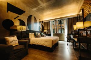 马六甲罗莎马六甲酒店的一间卧室配有一张床、一把椅子和一张桌子
