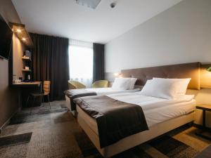 卡托维兹卡托维兹普乐斯Q酒店的酒店客房配有两张床和一张书桌