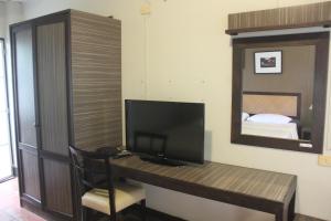 清莱班瓦拉博德酒店的客房设有一张带电视和镜子的书桌