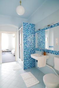 维也纳芬克经济客房旅馆的浴室设有卫生间、水槽和蓝色瓷砖。