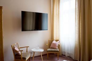 维也纳芬克经济客房旅馆的一间设有两把椅子和一张桌子的房间,墙上设有一台电视机