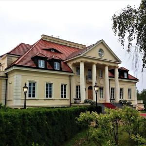 PniewyDwor Osieczek的一座大型白色房屋,设有红色屋顶