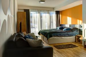 恩斯塔尔豪斯恩斯塔尔豪斯西西公园酒店的卧室配有一张床,窗户前配有一张沙发