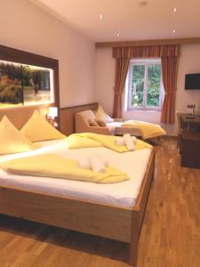 韦尔特湖畔克伦彭多夫古特德拉辛旅馆的一间卧室配有两张带黄床单的床