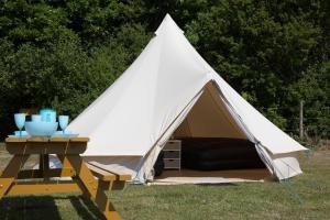 斯沃尼奇Herston Caravan & Camping的白色帐篷,在草地上设有野餐桌