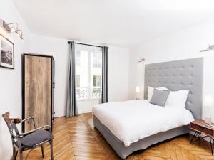 巴黎LivinParis - Luxury 4 Bedrooms Opera Lafayette II的卧室配有一张白色大床和一把椅子