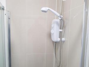 恩菲尔德卡瑟林优质公寓式酒店的浴室内带电话的淋浴