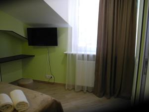 第比利斯Cherdachok的一间卧室配有床和带毛巾的窗户。