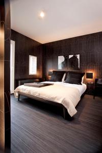 阿纳姆莫得兹名家设计酒店 的一间卧室设有一张大床和黑色墙壁
