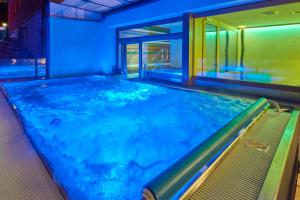 格林德尔瓦尔德阿斯彭阿尔卑斯休闲酒店的蓝色灯光的房间的游泳池