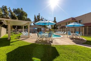 印地欧印第安棕榈度假俱乐部酒店的游泳池旁带椅子和遮阳伞的天井