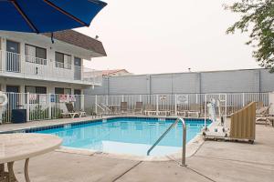 卡利斯佩尔卡利斯比6号汽车旅馆的一个带桌子和遮阳伞的酒店游泳池