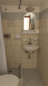 爱琴娜岛马默里诺斯酒店的一间带卫生间、水槽和镜子的浴室