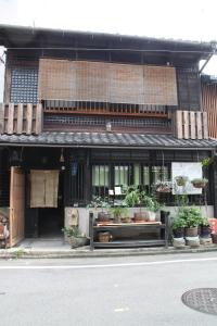 京都画廊诺泽酒店 的街道边有盆栽植物的建筑