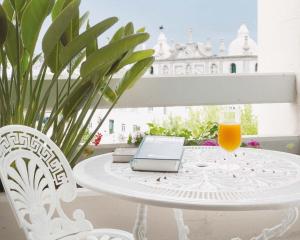 庞巴尔卡达尔酒店的一张带笔记本电脑的白色桌子和一杯橙汁
