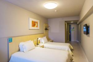 中卫锦江之星品尚中卫沙坡头水镇酒店的一间酒店客房,设有两张床和电视