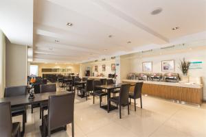 中卫锦江之星品尚中卫沙坡头水镇酒店的餐厅设有黑色桌椅和柜台