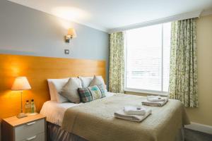牛津牛津乔治酒店的一间卧室配有一张床,上面有两条毛巾