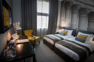 泰恩河畔纽卡斯尔利基格雷街酒店的酒店客房设有两张床和一张桌子。