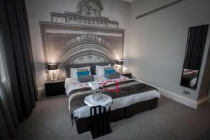 泰恩河畔纽卡斯尔利基格雷街酒店的一间卧室配有一张大床和大床头板