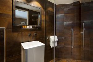 巴黎黑猫酒店的浴室配有盥洗盆和带镜子的淋浴