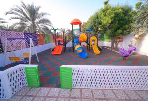 富查伊拉Fujairah Hotel & Resort的一个带滑梯和游戏设备的儿童游乐场