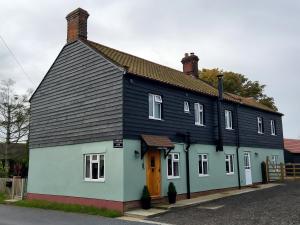 HicklingLawson Cottage B&B的白色和蓝色的房屋,有黑色的屋顶