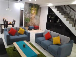 新山Escape to Bukit Indah Legoland Retreat Your 5BR Homestay for 1-16 Guests的客厅设有两张沙发和一个楼梯