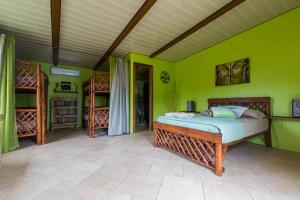 CopecitoCabanas Los Colibris的一间卧室设有一张床和绿色的墙壁
