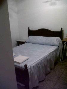 奥尔维拉Hostal Medina的一间卧室配有一张带木制床头板的床