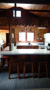 卡尔卡斯卡Log Cottage on Blue Lake的厨房配有大型白色柜台和木桌