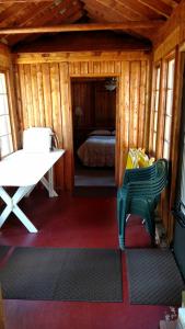 卡尔卡斯卡Log Cottage on Blue Lake的小屋内带绿椅的房间