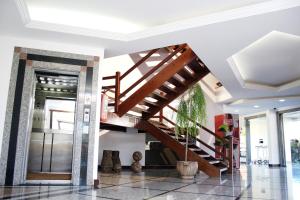 伊塔佩鲁纳Hotel Caiçara Bistrô e Eventos Ltda的木楼梯,位于带大堂的房间