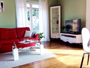 奥尔什丁NEPTUN 46 - 2 sypialnie的客厅配有红色沙发和电视