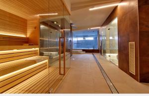 卡奥莱Hotel Elite的一间带玻璃墙和步入式淋浴间的桑拿浴室