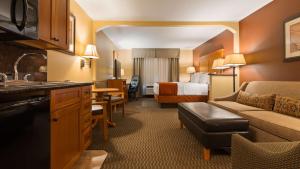 克雷格Best Western Plus Deer Park Hotel and Suites的酒店客房设有床和客厅。