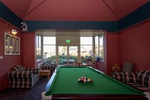 肯图巴拉麦森精品酒店的红色墙壁的房间里设有一张台球桌