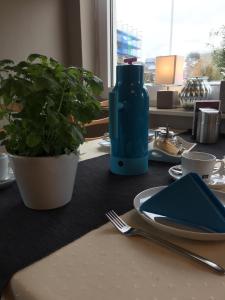库克斯港Haus Meeresgruß的一张桌子,上面有蓝色的瓶子,盘子和植物