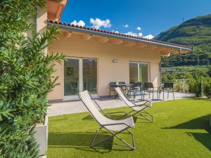 德利纳La Gazza Ladra Apartments - Garda Chill Out的草坪上配有桌椅的庭院