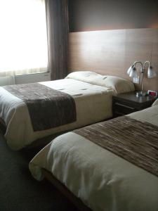 Bécancour康姆普莱克斯55号酒店的酒店客房设有两张床和窗户。
