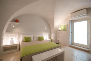 滨海波利尼亚诺Palazzo Maringelli的一间卧室配有一张带绿色床单的床和一扇窗户。